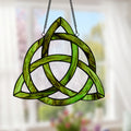 11.75" H Trinity Knot Celtic Stained Glass Window Panel hanging against a blurred window background