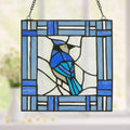 11"H John the Blue Jay Stained Glass Window Panel hanging in a window