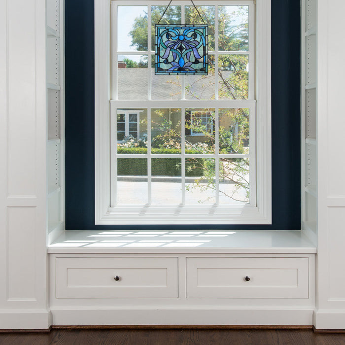 12" H Ilsa Stained Glass Window Panel hanging in a window with white frame and storage drawers.