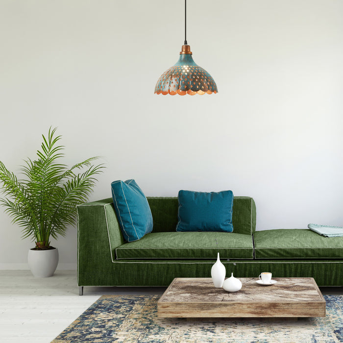 12" W 1-Light Orlando Faux Blue Patina Metal Pendant in a room setting with a green sofa with blue pillows with a plant and coffee table.
