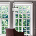 13" W Trudie Clear and Black Glass and Metal Pendant Light in a living room with large windows and a brown chair.