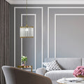13" W Trudie Clear and Gold Glass and Metal Pendant Light in a modern living room with gray walls, a gray sofa, and decorative elements.