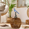 13.5"H Stained Glass Bird Accent Lamp on a wicker table in a cozy living room.