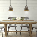 13"H Pierced Brushed Metal Cone 1-Light Pendant in a dining room with wooden table and chairs against a white paneled wall.