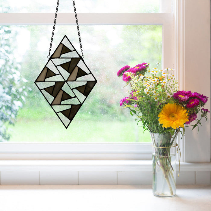 14" H Bette Stained Glass Window Panel hanging in a window with a vase of flowers beside it.