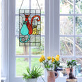 14-Inch Coy Cats Trio Stained Glass Window Panel hanging on a window, with plants and a mug below.