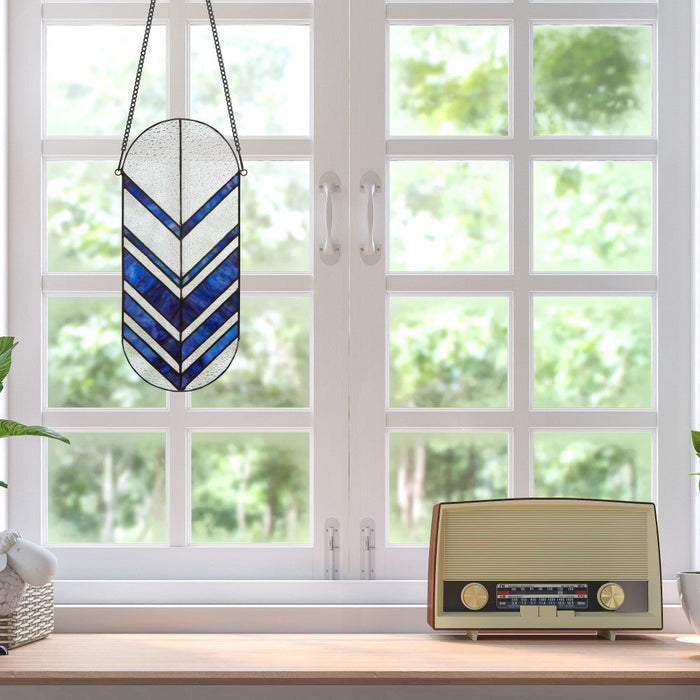 14"H Darby Blue Arrows Stained Glass Window Panel hanging in front of a window with a vintage radio on a windowsill.