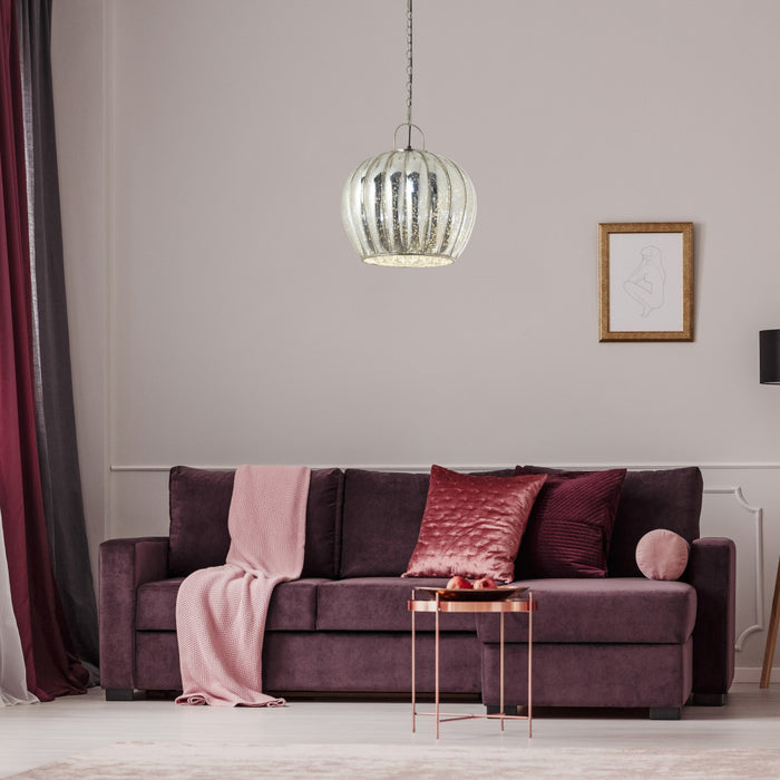16 in. Nickel-Finish 1-Light Pendant with Silver Mercury Glass Shade in a  living room with a purple sofa, pink blanket, and pillows.