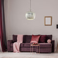 16 in. Nickel-Finish 1-Light Pendant with Silver Mercury Glass Shade in a  living room with a purple sofa, pink blanket, and pillows.