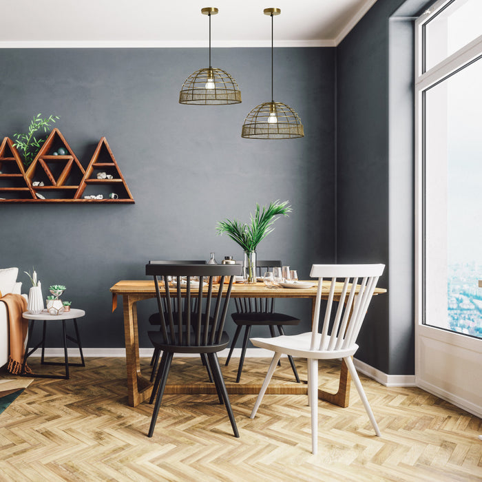 16" W Clara Industrial Gold Dome Shade Pendant in a dining room with wooden table, chairs, and decorative elements against a gray wall.