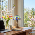 17" H Halston Candlestick Base Dome Shade Table Lamp in a home office desk with laptop, mug, and notebook in a bright room with flowers and windows.