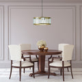 17" W Angelina Gold Metal and Beveled Glass Pendant in a dining room with wooden table and chairs.