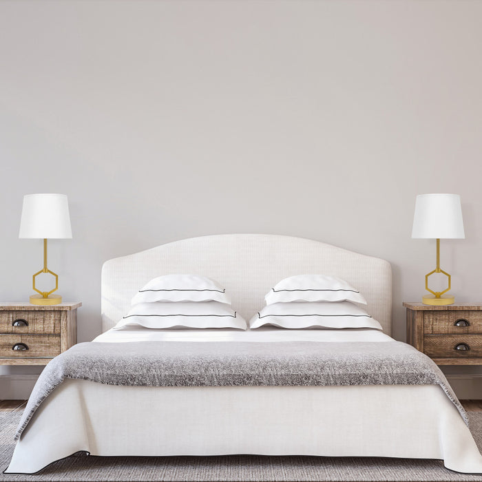 17.75"H Marler Gold & White Twin Table Lamps next to a neatly made bed with white bedding and gray blanket in a bedroom setting.