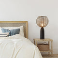 18.5" H Woven Brass Tone Wire Globe Shade Pillar Table Lamp on a bedroom nightstand next to a bed.