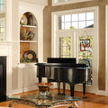 18"H Tiffany Style Stained Glass Mystical World Tree Window Panel hanging in a window in a room with a grand piano and decorative elements
