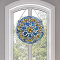 19.5"H Chartres Cathedral Stained Glass Window Panel hanging in front of a window with a view of trees.