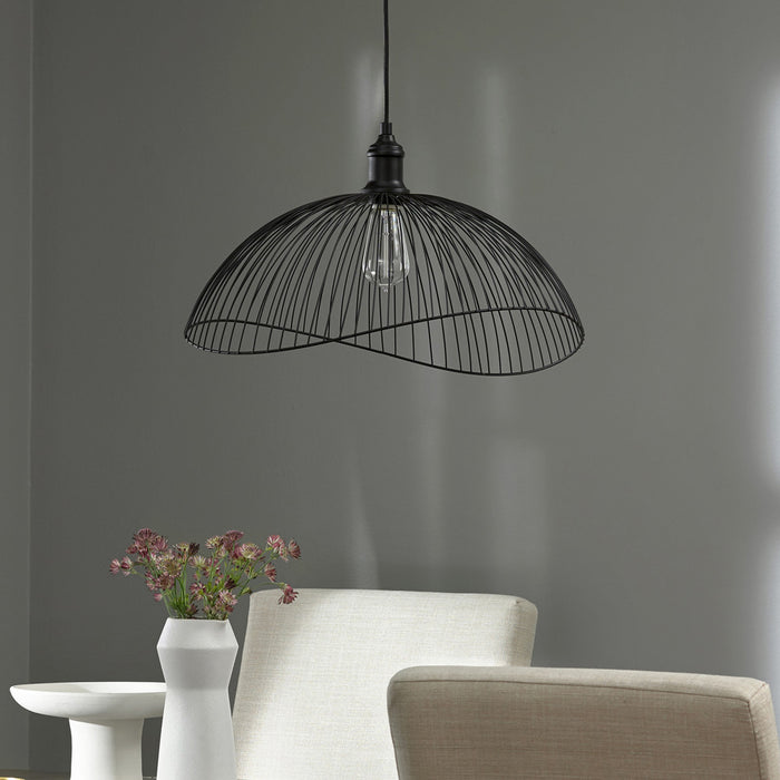 19.75" 1-Light Brigitte Pendant Light Black hanging above a white chair and table against a gray wall.