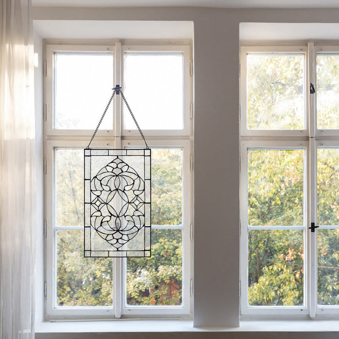 20" H Clear Floral Beveled Glass Window Panel hanging in front of a window with a view of trees.