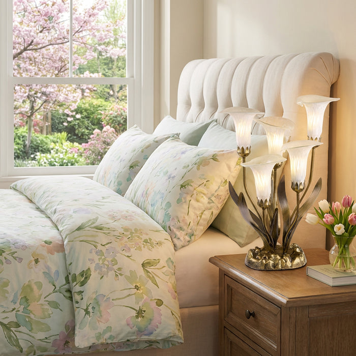 20"H Hand Blown Glass 5 Calla Lily Uplight Accent Lamp in a dedroom with floral bedding and flowers on a nightstand.