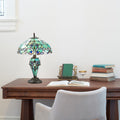20"H Tiffany Style Magna Carta Stained Glass Double Lit Table Lamp on a wooden desk with books and a chair.