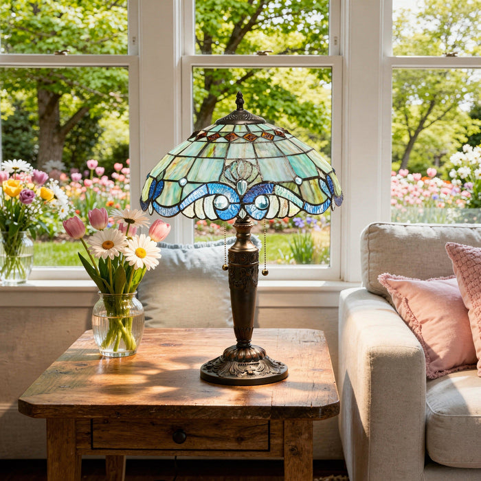 20"H Vivienne Baroque Style Stained Glass Table Lamp on a wooden table with flowers and a couch in a sunlit room.