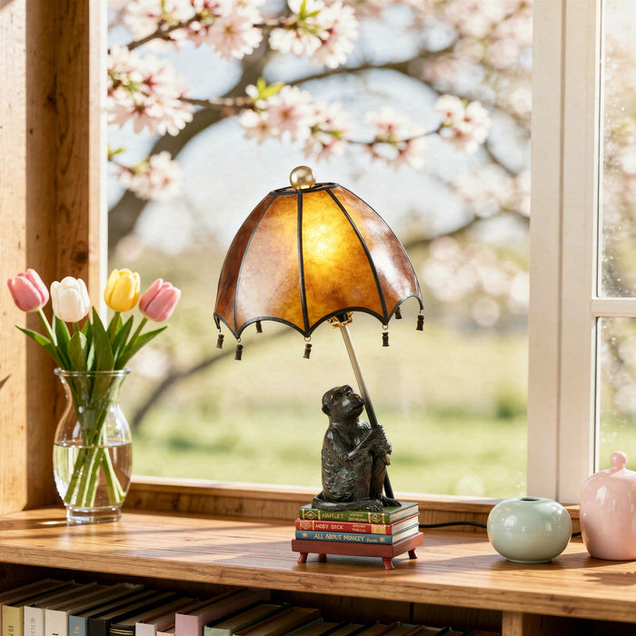 21.75"H Intellectual Monkey Table Lamp on a wooden surface near a window with cherry blossoms.