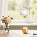 21"H Eagan Globe Shade Table Lamp on a surface next to a vase of flowers.