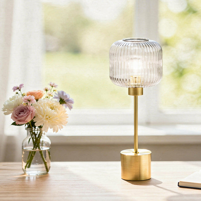 21"H Eagan Globe Shade Table Lamp on a surface next to a vase of flowers.