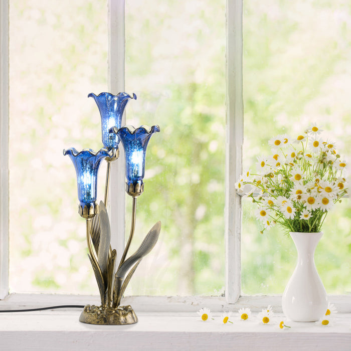 21"H Mercury Glass 3 Lily Uplight Accent Lamp on a windowsill with a vase of flowers.