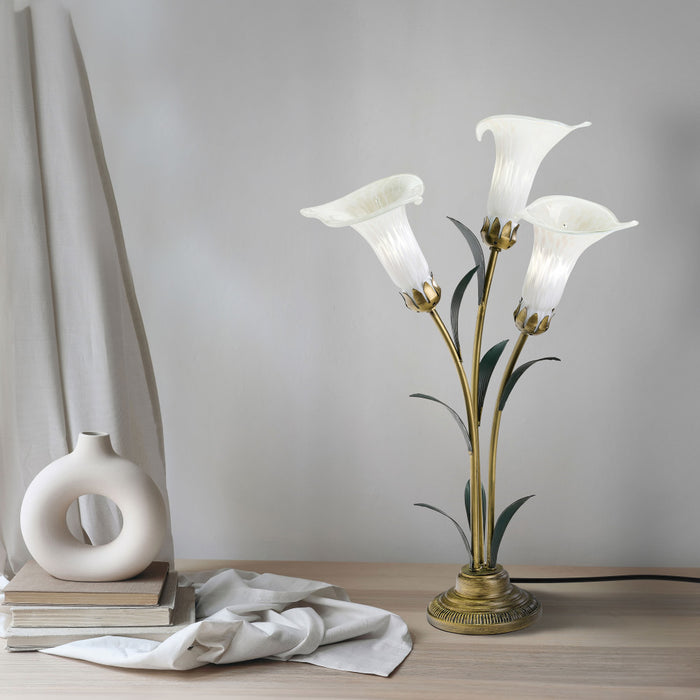 23.5"H Hand Blown Glass 3 Calla Lily Uplight Accent Lamp on a wooden surface next to drapes, books and a vase.