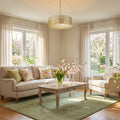 23.5"W Bryar Brass and Crystal 3-Light Chandelier in a living room with beige sofa, wooden coffee table, and floral arrangements.