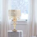24"H Jeweled Blossoms Table Lamp on a round white table in a room with sheer curtains.