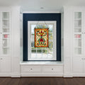 24"H Tiffany Style Stained Glass Fiery Hearts and Flowers Window Panel hanging in a window in a room with white cabinets.