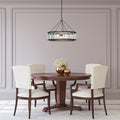 25" W 3-Light Gwen Black Metal and Glass Pendant in a dining room with wooden table and chairs.