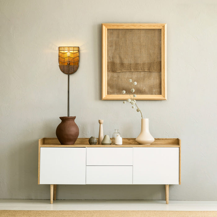 25.75"H Brushed Gold Iron Wall Sconce with Hemp Rope Shade in a modern interior with a wooden sideboard, and framed artwork on a light gray wall.