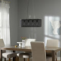 30" 4-Light Gianna Chandelier Black in a dining room with wooden table, chairs and abstract painting on gray wall.