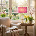 30.5" H Colette Fuchsia Drum Shade Geometric Glass Table Lamp in a cozy living room with a beige armchair and floral arrangements.