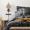 32.75"H Candlestick Wall Sconce with Tan Rattan Shade in a bedroom with gray bedding and gold blanket