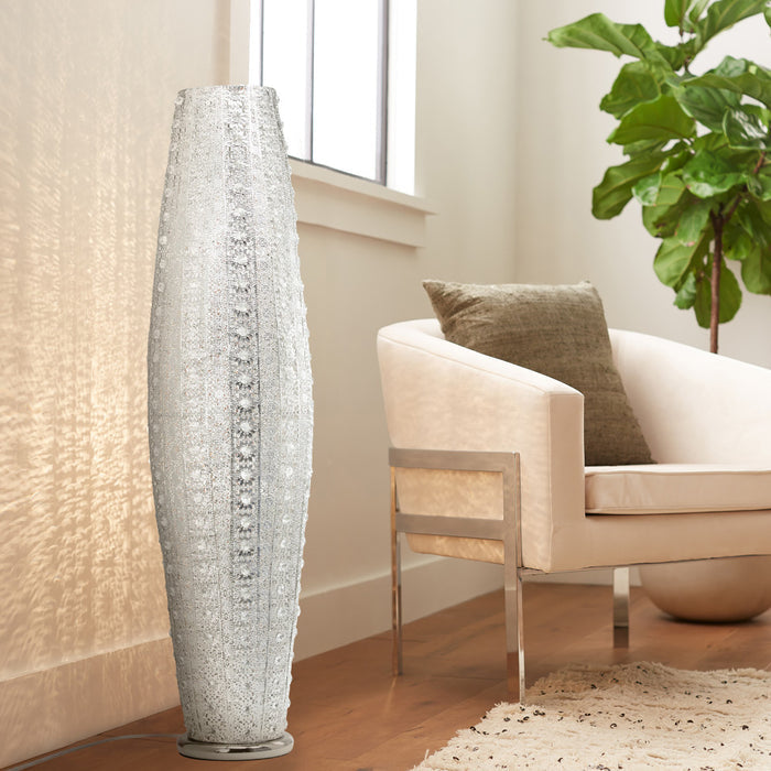 43.5"H Oversized Punched Metal 2-Light Floor Lamp next to a beige armchair with a plant in a living room setting.