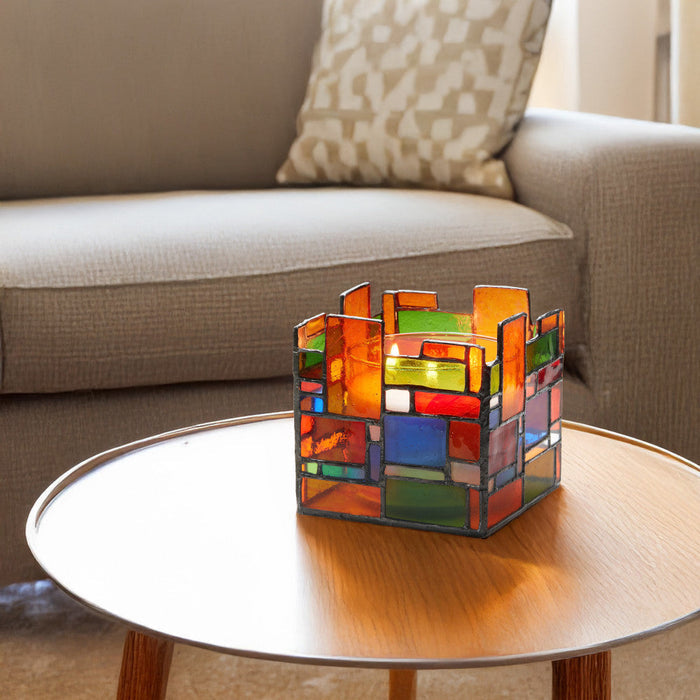 4.75" W Tiffany-Style Geometric Stained Glass Candle Holder on a wooden coffee table with a couch in the background