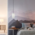 6" W Austin Glam White and Clear Glass Globe Shade Pendant Light in a modern bedroom with mountain-themed wallpaper, bed, and side table.