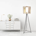 60" H Theo Gold Punched Metal Tripod Floor Lamp in a minimalistic room.