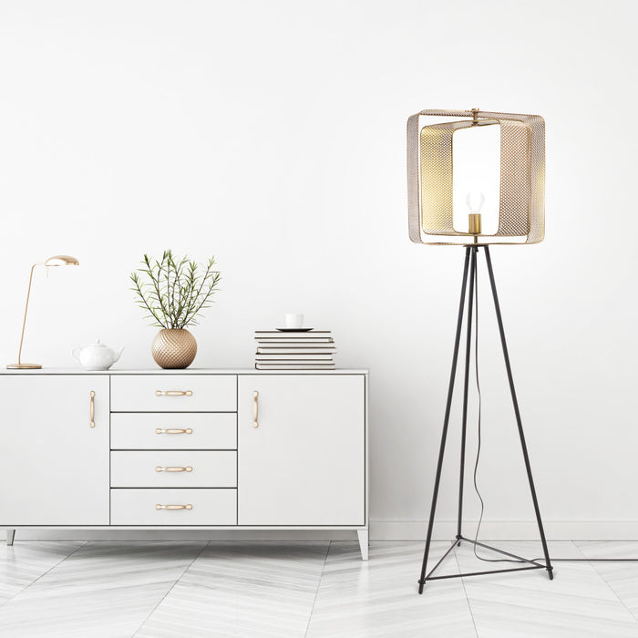60" H Theo Gold Punched Metal Tripod Floor Lamp in a minimalistic room.