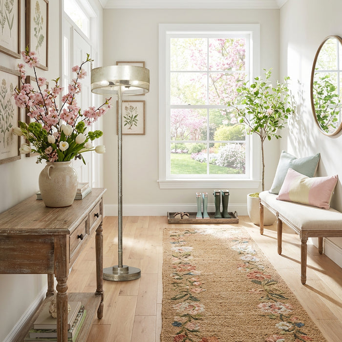 62" H Veronica Aged Silver-Finish Metal Floor Lamp in a living room with floral arrangement and a bench