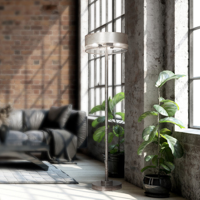 62" H Veronica Aged Silver-Finish Metal Floor Lamp in a modern living room with plants and a sofa.