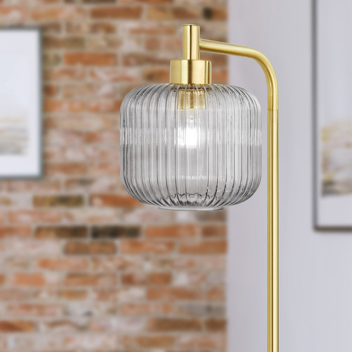 63"H Rowan Globe Shade Floor Lamp against a brick wall.