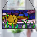 8.25"H Purple Cattails at Sunset Stained Glass Window Panel, suspended by a black metal chain against a blurred indoor background.