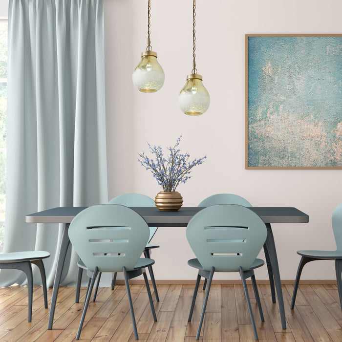 9 in. Gold 1-Light Pendant with Gold and Cream Ombre Mercury Glass Shade in a dining room with a table and chairs, decorative elements, and a painting on the wall.