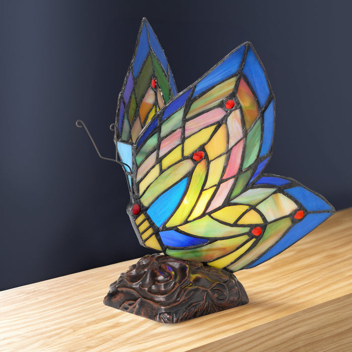 9.5"H Stained Glass Butterfly Wings Accent Lamp on a wooden surface with a dark background