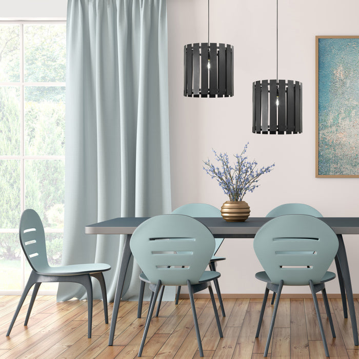 9.75" W 1-Light Westley Black Metal Pendant in a dining room with a table and chairs near a window with light blue curtains.